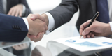 Shaking Hands Over Desk