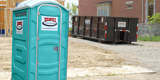 Portable Restroom And Roll Off Dumpster On A Construction Site